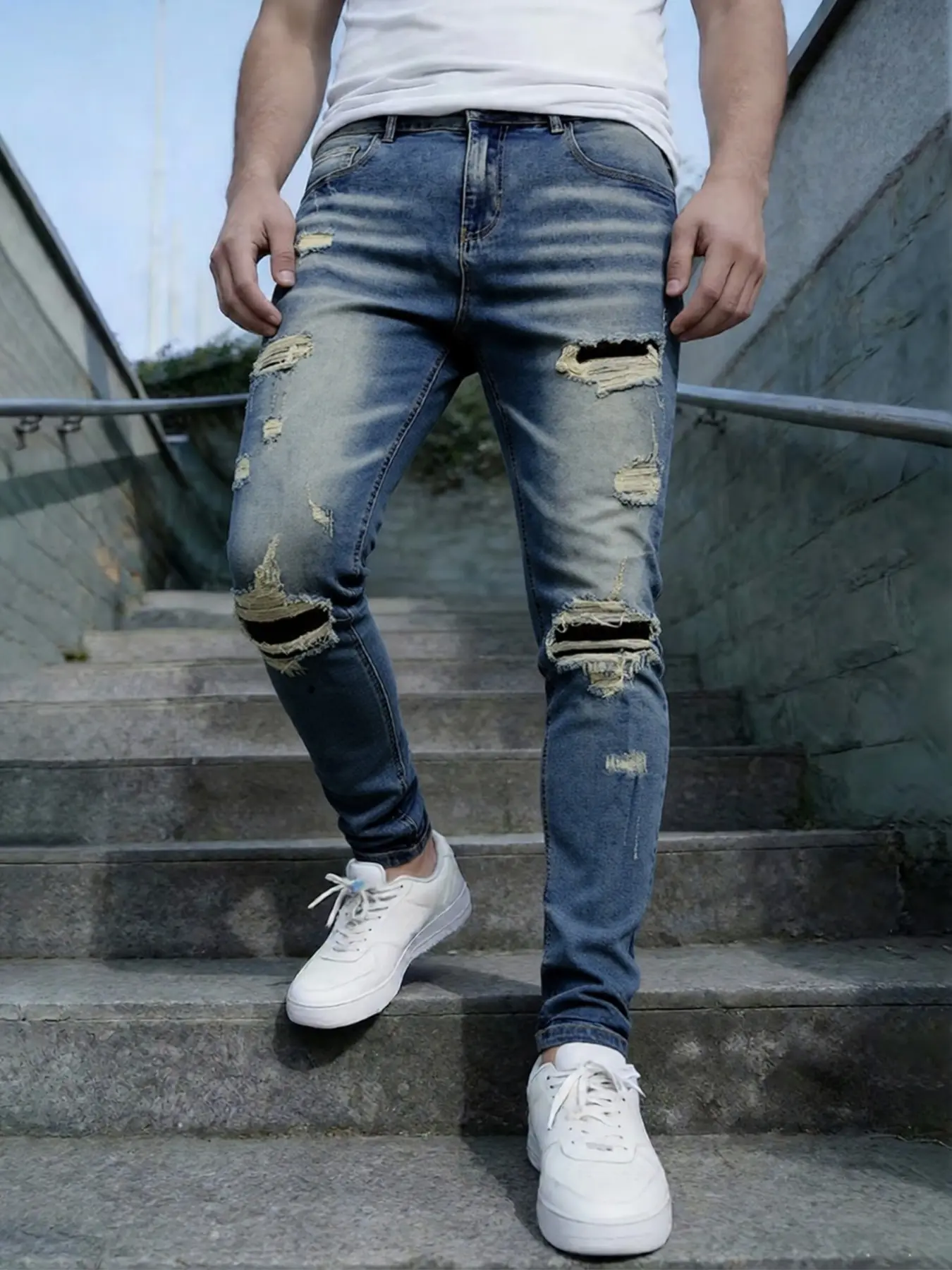 Men's blue distressed and ripped stretch jeans, with a slim-fit street silhouette for a narrative masterpiece, featuring unique patches to reconstruct vintage memories, allowing seamless switching between commuting and street scenes with one click