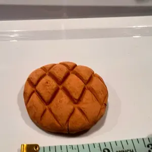 2 inches clay in a form of a conchita. Made in Mexico