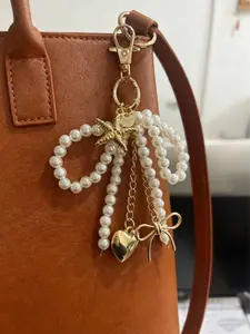 Gentle, fashionable and exquisite pearl bead string decoration, embellished with starfish love bow design, can be used as a bag hanger, keychain, and Charms for bags, suitable for wearing on dates, shopping, and parties