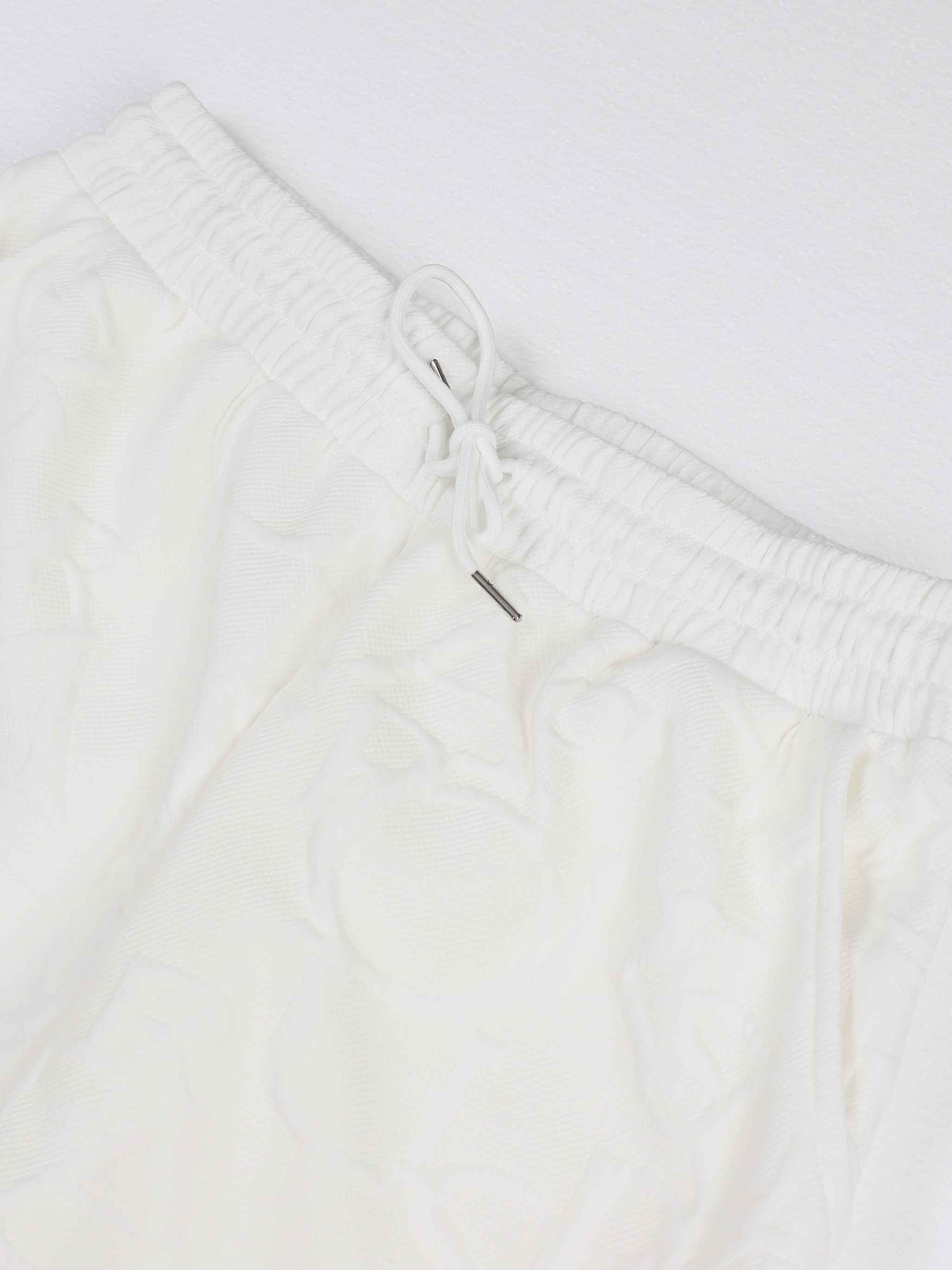 Elastic drawstring waistband on white textured trousers