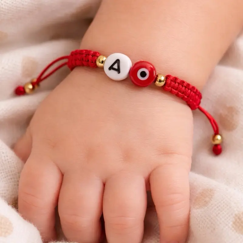 Adjustable red bracelet with evil eye and initials. Adjustable red bracelet with evil eye and initials.