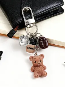 A cute and fun keychain charm in the shape of a coffee cup and teddy bear, featuring a knitted-style teddy bear, a mini coffee cup, coffee beans, and a sparkling heart charm, made of mini resin material as a bag accessory, Keychain For Bags