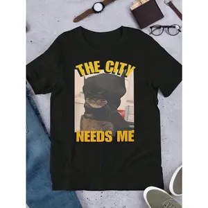 A T - shirt featuring a humorous cat - Batman design and the phrase “THE CITY NEEDS ME”, great for quirky fashion lovers
