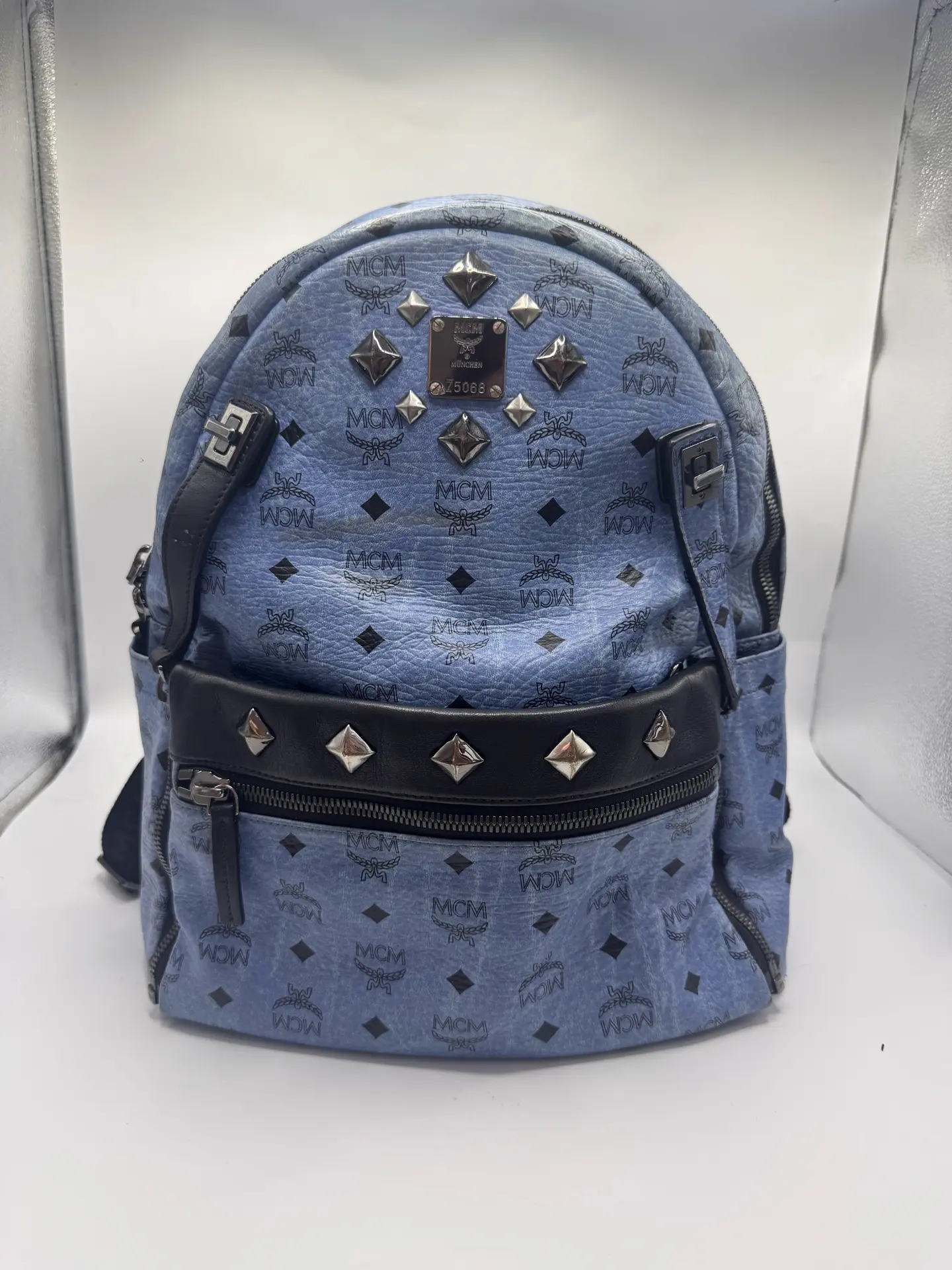 Pre-owned MCM Large Backpack in Haze Blue with All Over Logo Print and Stud Detailing.