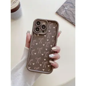 A heart-shaped bow design camera protection shockproof coffee brown phone case, compatible with iPhone 17/16/15/14/13/12/11/X/XS/XSMAX/12.13MINI, cute style, bow pattern, a gift for family, friends, or oneself.
