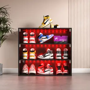 Black LED-lit stackable shoe storage, three tiers with glass doors, meticulously crafted from wood, holds up to 9 pairs of sneakers.