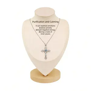 A cross necklace imbued with protective energy, featuring exquisitely set blue-white sapphires—blue gemstones—inspired by a designer’s original concept and conveying the Christian faith’s blessing of peace.