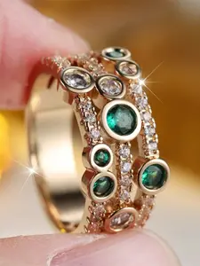 A geometric design ring featuring synthetic green crystal zirconia, in a stylish, retro gold tone, Vintage Crystal Ring, suitable for wearing at weddings.