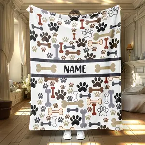 Customizable dog-themed blanket featuring paw prints and bones, perfect for camping or office use. This lightweight flannel blanket is soft and warm, making it an ideal choice for bedding, sofas and travel.