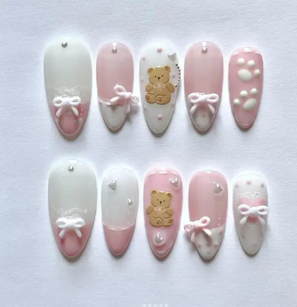 Cute Teddy Nails – Soft pink and white pastel tones with 3D bows, pearls, lace, and teddy bears, creating an adorable and cozy kawaii-inspired nail design.