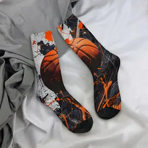 The orange basketball is surrounded by orange, black, and white splatter patterns; the mid-calf socks have a casual, sporty style and are soft and comfortable.