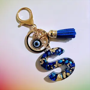 A fashionable blue resin letter keychain with a devil's eye and blue tassels, a key chain, bag pendant, wallet decoration, suitable for ladies' daily use and as a small gift for friends