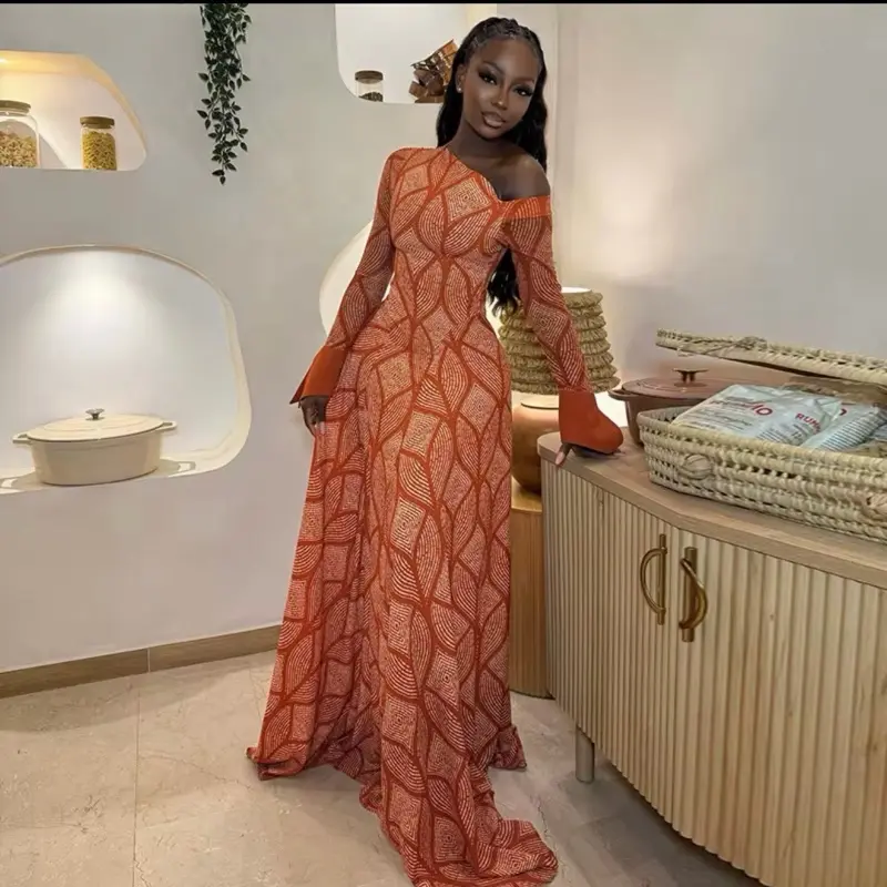 Elegant burnt orange off-shoulder maxi dress with geometric patterns and flowing sleeves.