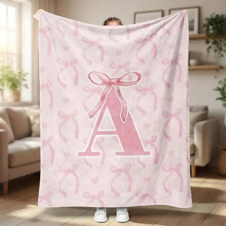 Personalized Pink Bow Letter Flannel Throw Blanket with customizable A-E letter name design, ultra soft cozy coquette aesthetic layout, sentimental keepsake gift matching fresh warm seasonal home atmosphere