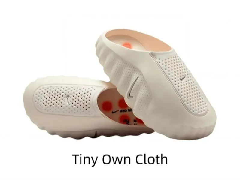 Minimal creamy off-white molded slide sandals with tiny orange traction nubs for summer casual fits