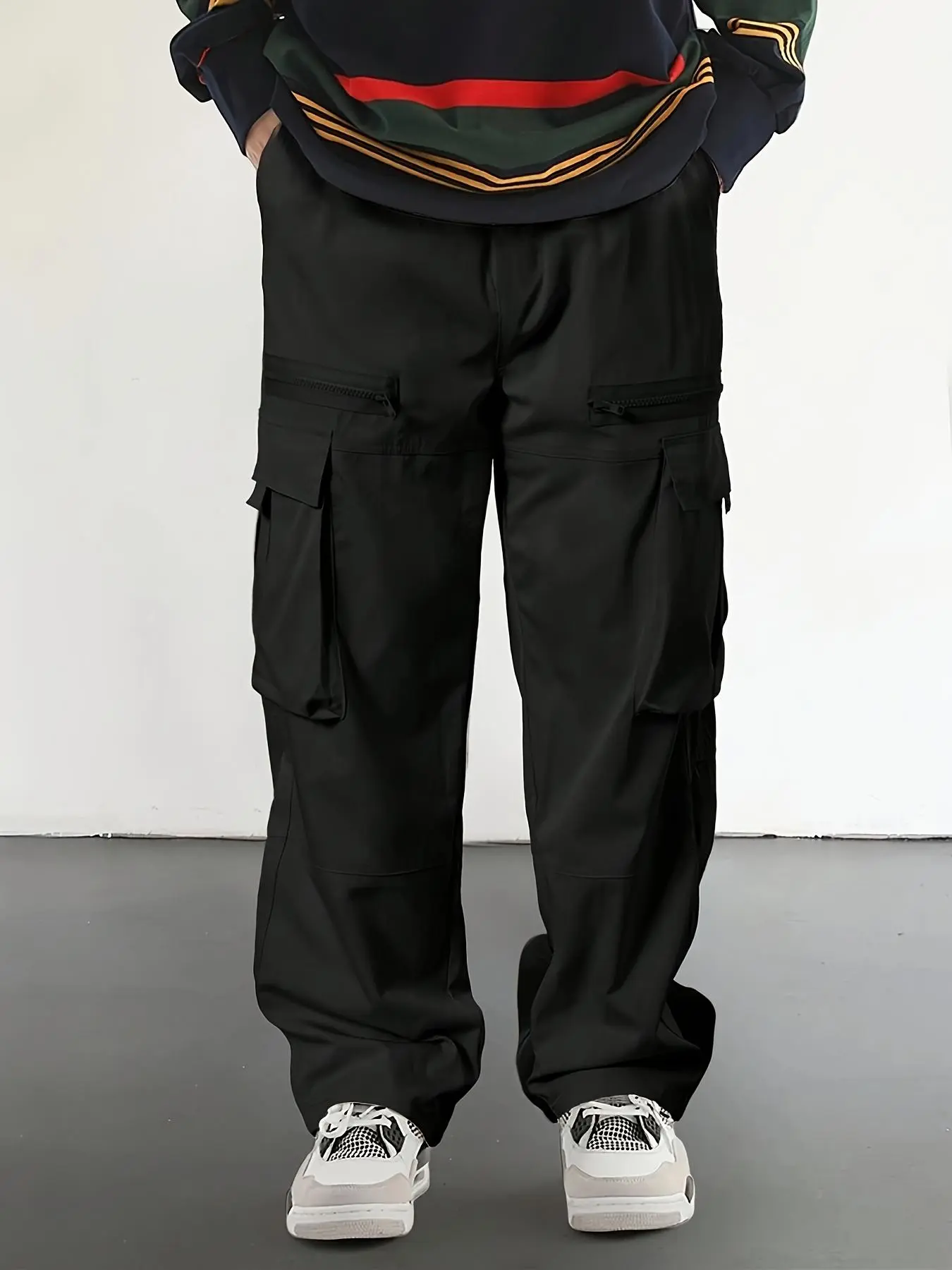 Men’s cargo pants for spring and autumn, featuring multiple pockets and zippered detailing, a loose straight cut. Streetwear styling, outdoor functional looks, and skate/street brand outfits for going out.