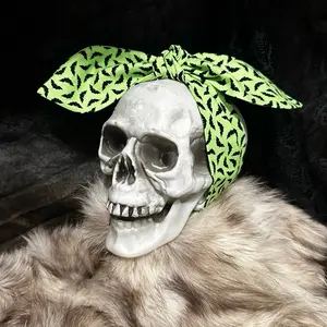 Lime green pinup style headband with a black bat design