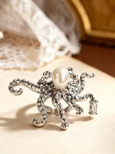 A silver octopus shaped ring featuring marine creatures, with a large central pearl paired with colored diamonds on the tentacles, suitable for wearing in dark or retro fashion, artistic events, and other settings.