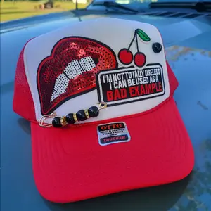 I'm not completely useless. I can be used as a bad example Otto trucker hat. Comes with lips, cherries, and flower patches.