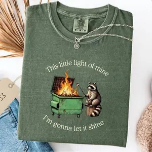 Comfort Colors funny parody shirt with a dumpster fire raccoon graphic, blending humor and light sarcasm into a soft, relaxed mental health tee for casual wear.