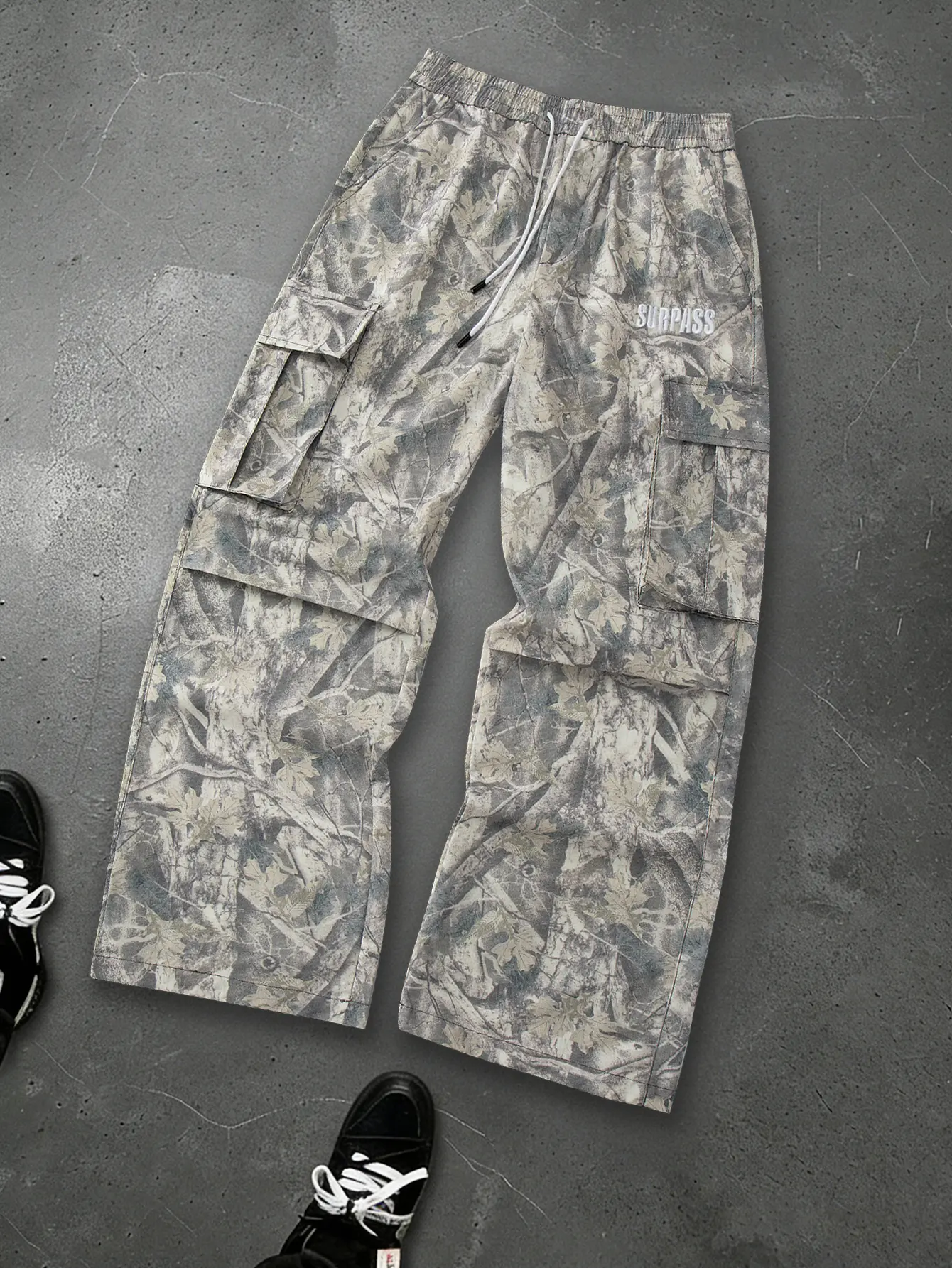 Men’s European/American retro camouflage cargo wide-leg pants featuring an allover print of bare branches and falling leaves; large side pockets; a loose, drapey straight cut; elastic waistband with two drawstrings; minimalist letter embroidery detailing;