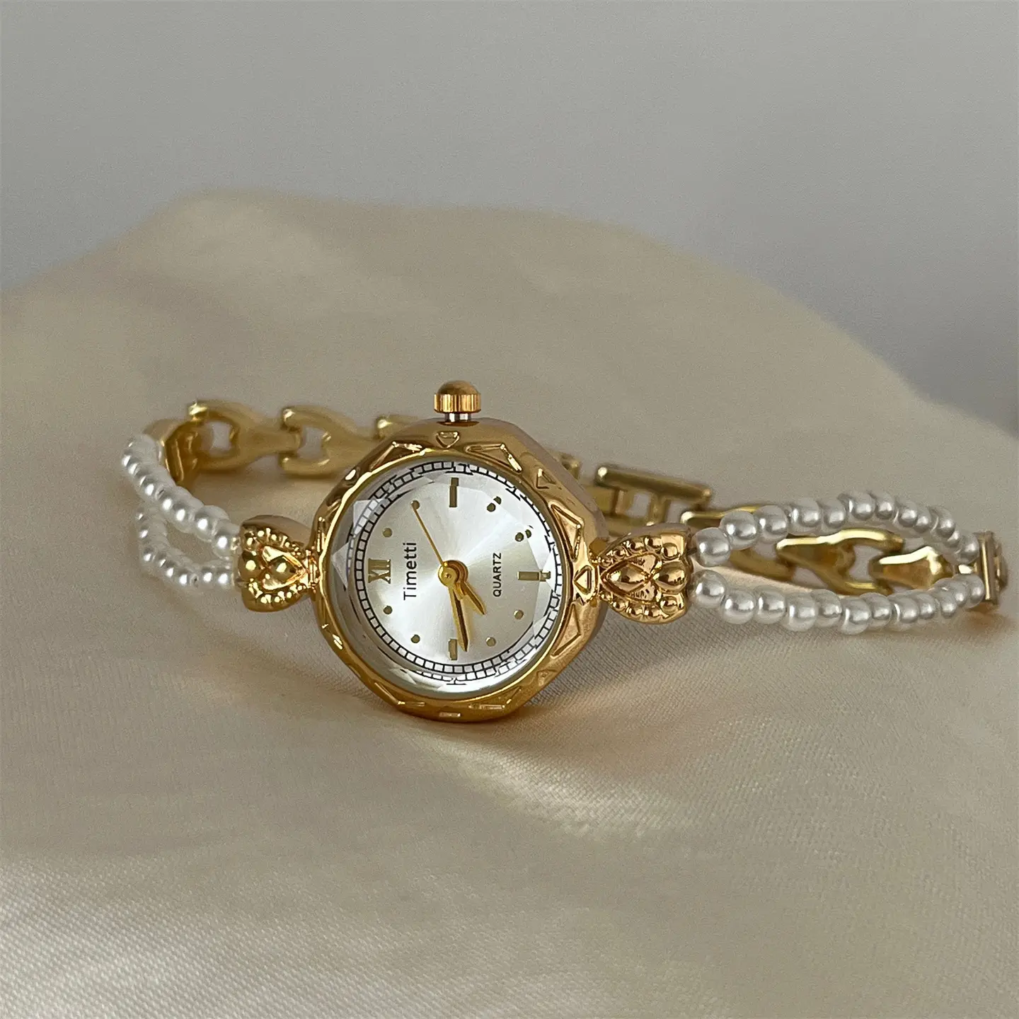 Elegant Pearl & Gold Tone Watch with Intricate Design and Timeless Appeal