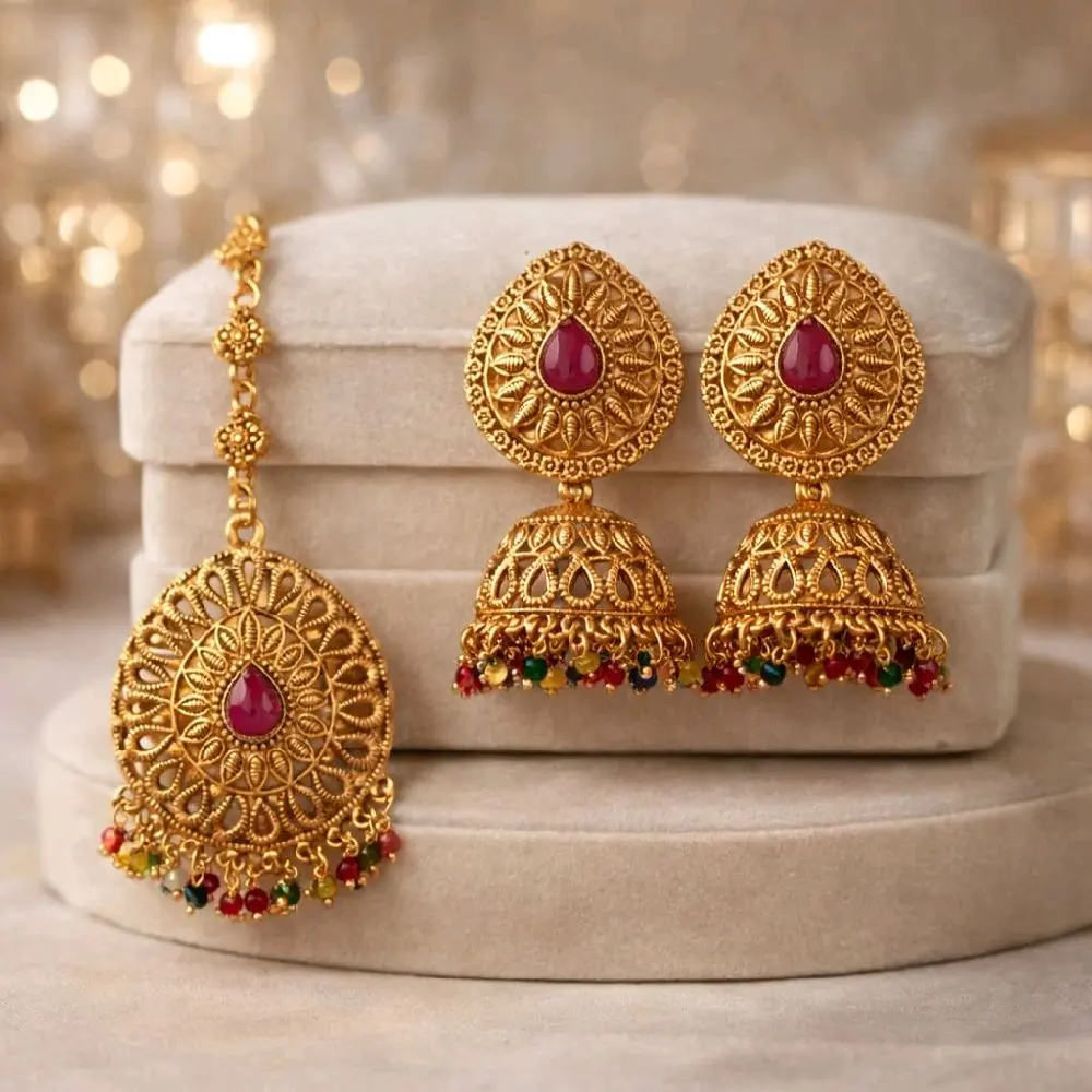 Gold Plated Jhumka and Tikka Set with Intricate Almond Design and Pearl Accents for Traditional Wear in Clear Gold and Pink Multi Colors