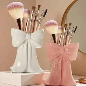 Cute tent-shaped bow-shaped makeup storage box, featuring a creative minimalist style flower vase for desktop decoration. Suitable for use in the living room TV cabinet, as well as for storing makeup brushes and office supplies. Makeup Organizer Box