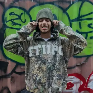 This 'TTUPO' camouflage jacket perfectly blends the ruggedness of workwear with streetstyle flair. Pair it with black leggings and sneakers for a relaxed, casual street style.