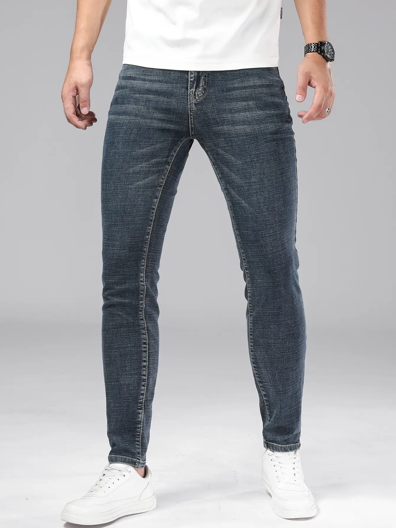 Soft, stretchy mid-blue jeans with a horizontal cat-whisker detail and slim legs—minimalist casual office trousers