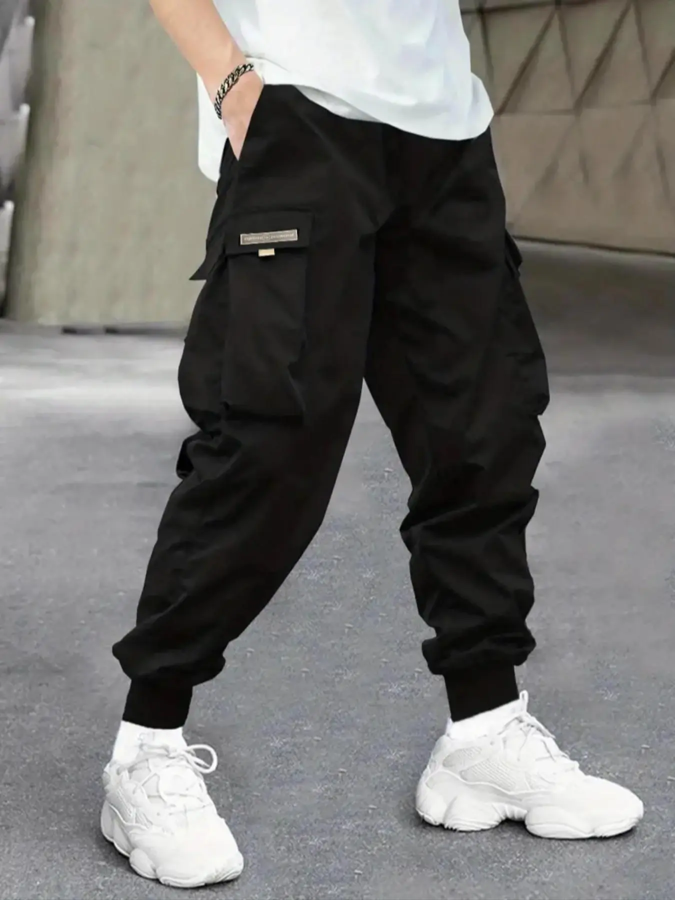 Men’s spring/autumn cargo jogger pants with side large pockets, cuffed ankles, a loose fit, and a tapered hem—ideal for streetwear styling, campus everyday wear, and functional looks.