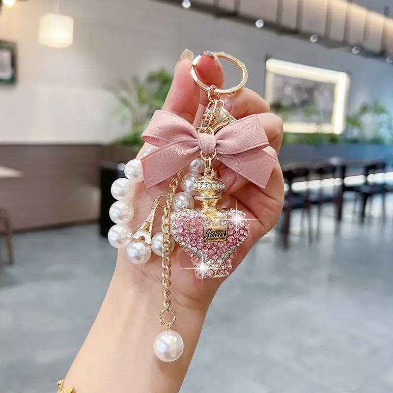 Creative Water Bottle Keychain Fashion Bow Perfume Bottle Bag Charm Keychain For Bags Elegant Pearl Chain Car Key Ring Gift Accessory Fashionable Alloy Keychain Stylish Keychain
