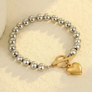 The "Color-Block Heart" Necklace features a striking contrast between its long silver beaded chain and a gold-tone toggle clasp and heart pendant—creating a versatile accessory perfect for achieving a layered look.