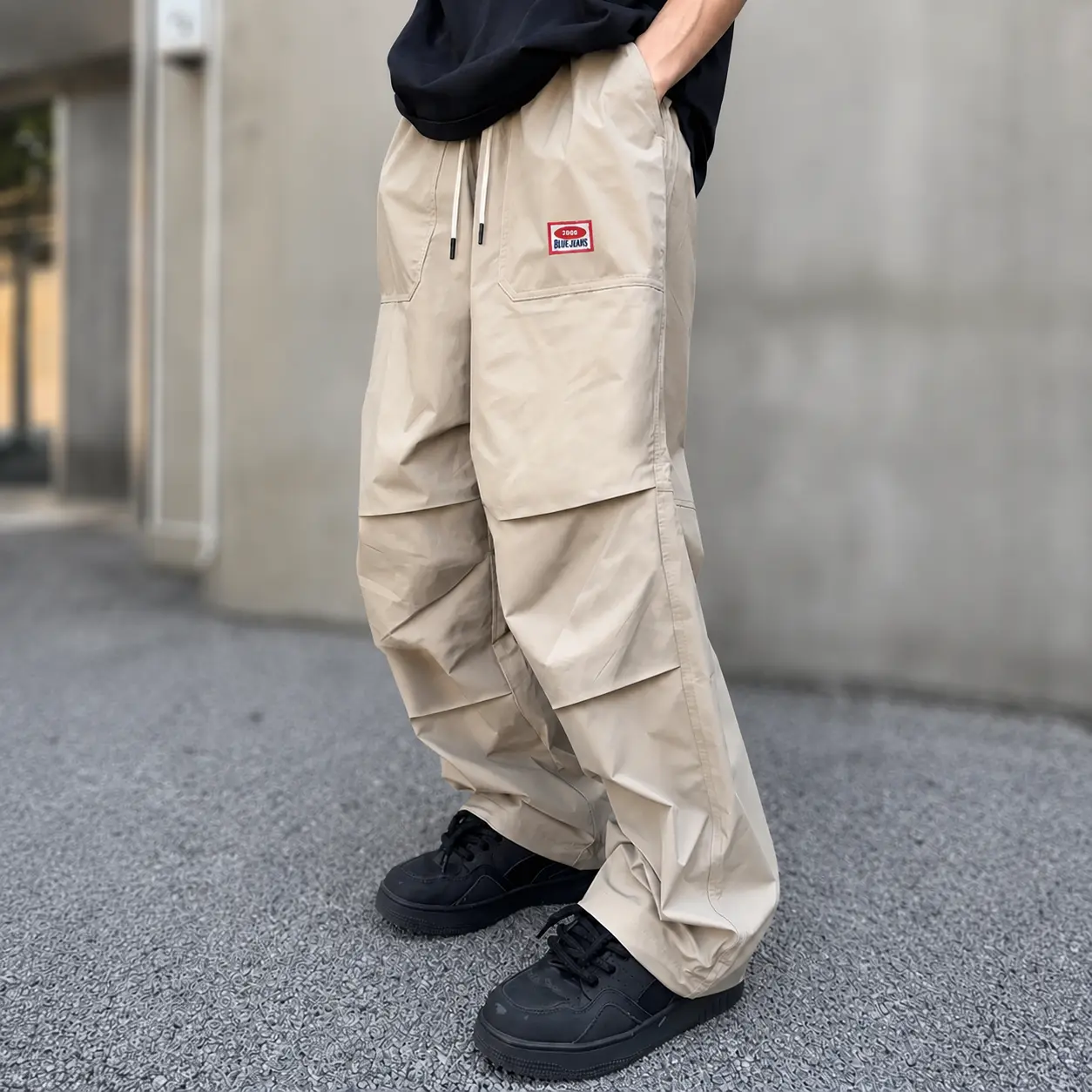 Men’s pleated wide-leg paratrooper cargo pants with a drawstring elastic waistband and small logo detailing; loose, casual streetwear long pants that are lightweight, breathable, and comfortable.