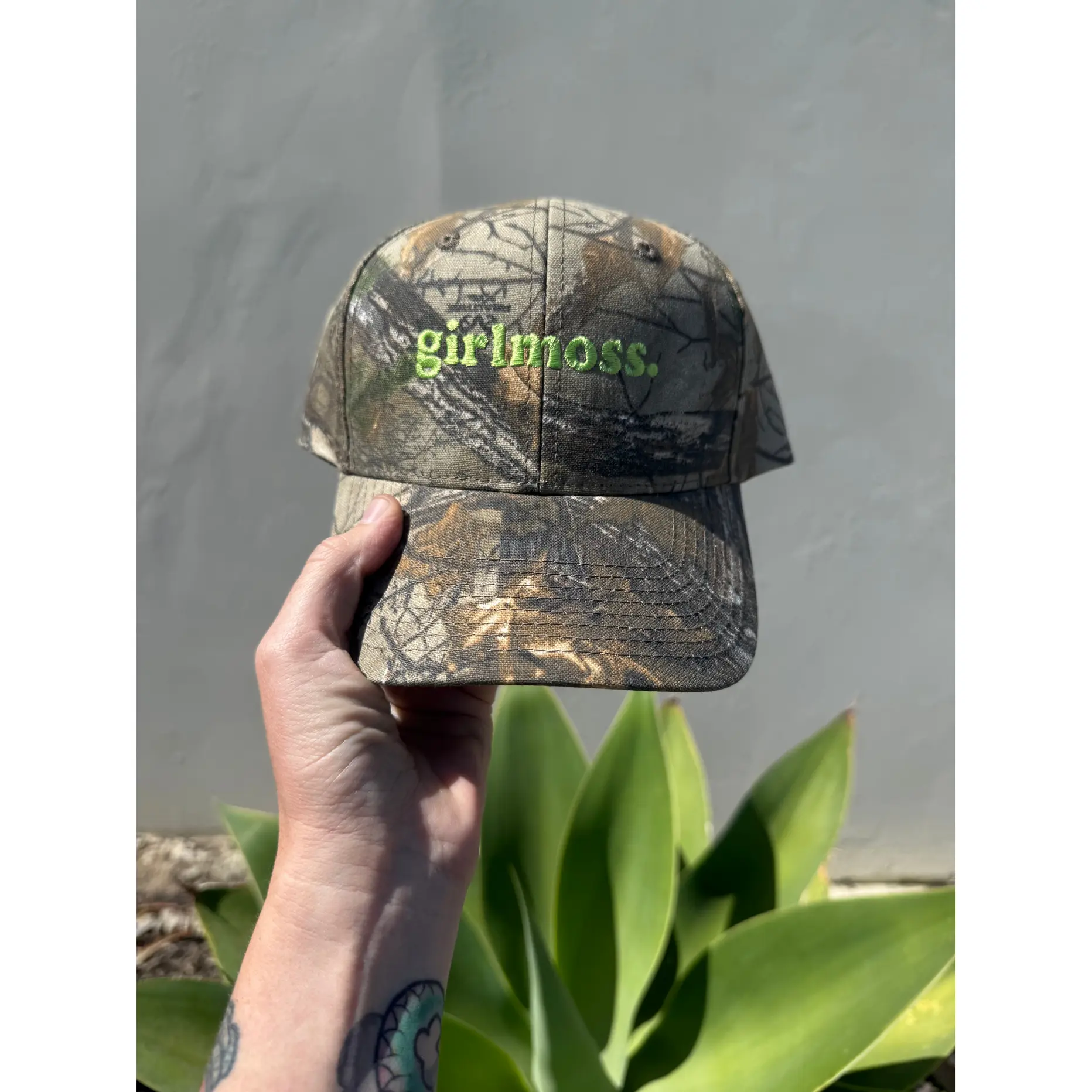 Girlmoss unstructured on camo dad hat with lime green thread.