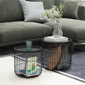 Two-piece round nesting coffee table set with black steel wire basket structure, stackable design, easy-to-clean tabletop, suitable for storing blankets and books in the living room.