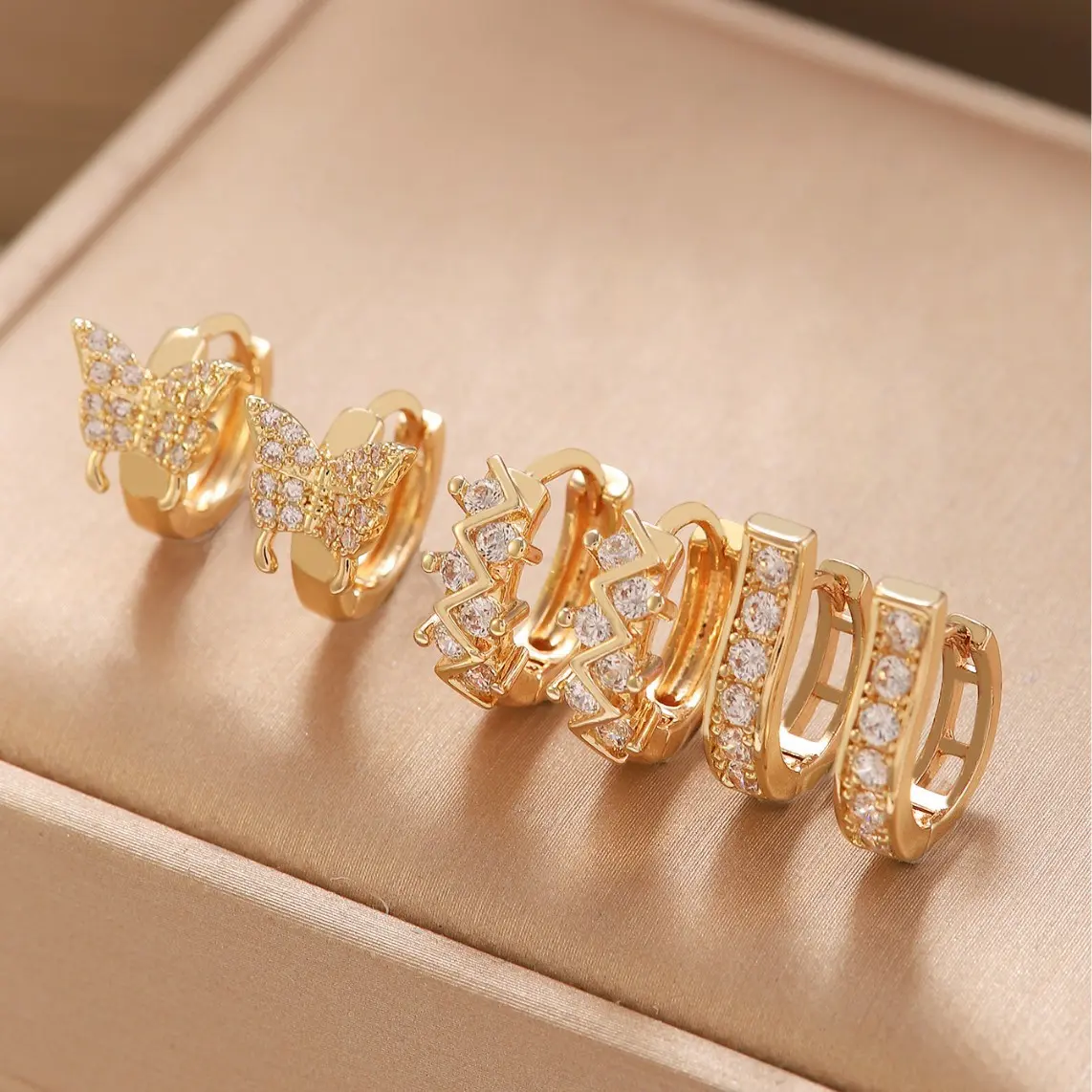 Exquisite 3-pair women's stackable hoop earring set, featuring butterfly-inspired geometric designs and circular close-fitting earrings, with hinged clasps