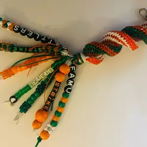 Rattlers Beaded Boondoggle Bag Charm Keychain Accessory with Green and Orange Beads and "Strike" Text