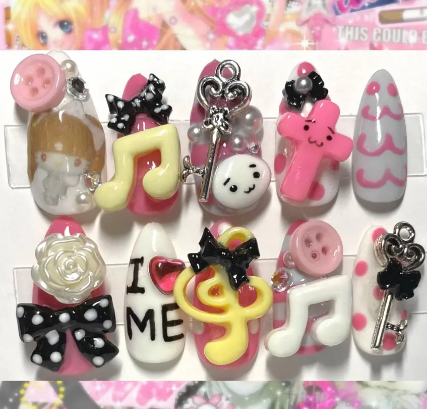 kawaii jpop inspired press on nails with 3d charms featuring music notes, bows, keys, roses, buttons, cute faces and playful pastel designs for a fun decora vibe