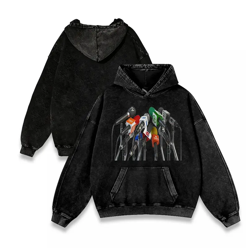 Soft pigment-washed distressed hooded sweatshirt featuring a bold microphone art print of a news reporter, relaxed fit casual top