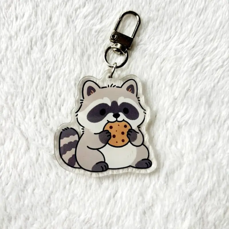 Cute cute raccoon keychain eating a chocolate chip cookie in acrylic