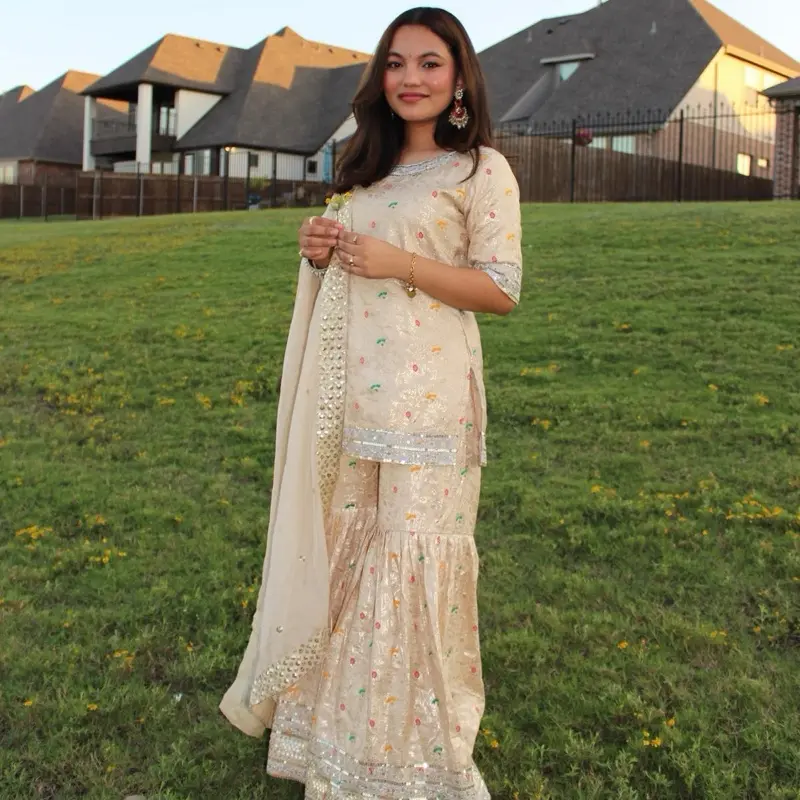 Royal embroidered beige sharara set, featuring delicate floral accents paired with a flowy dupatta and flare pants for a regal finish