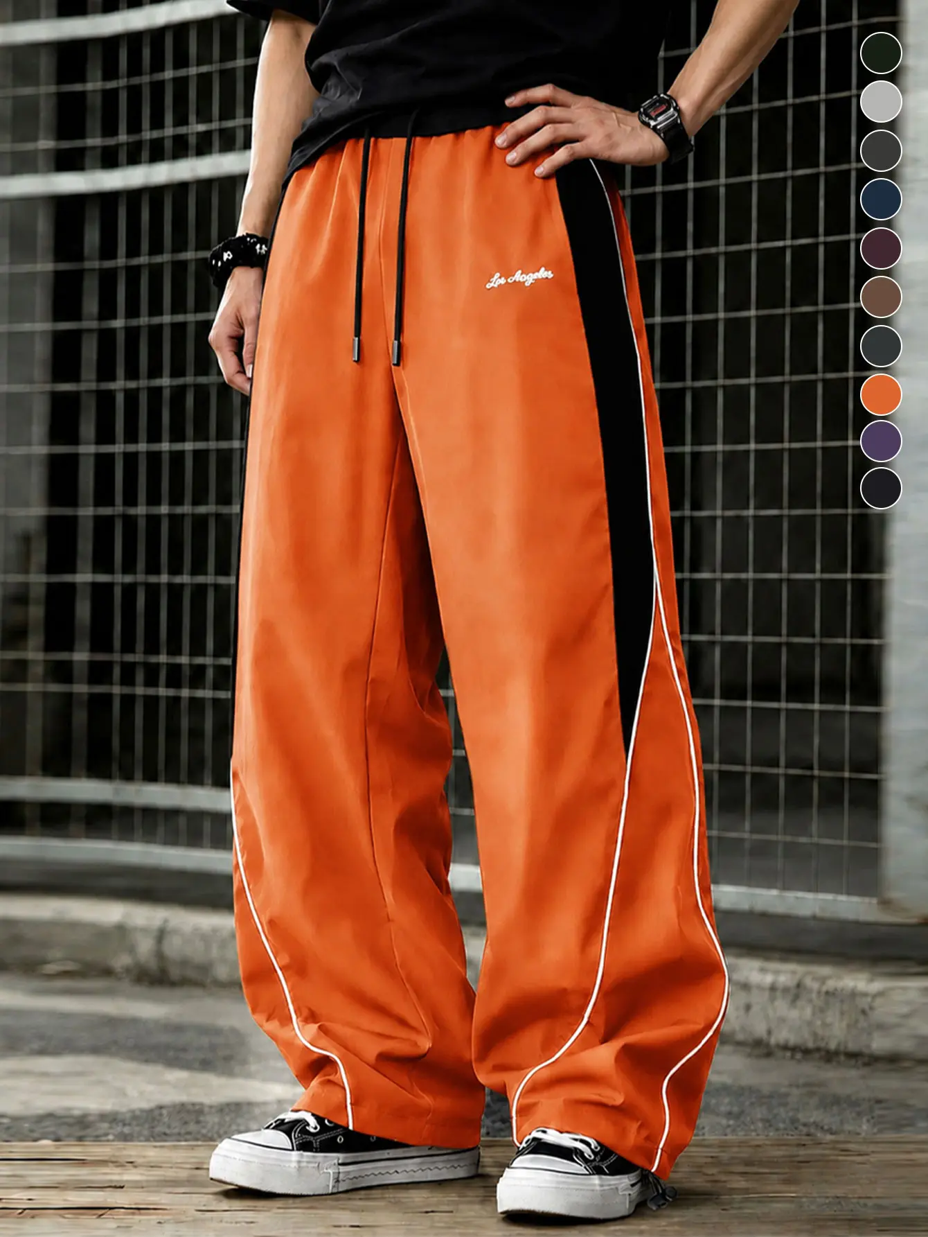 Men’s orange joggers with side stripes and drawstring; loose wide-leg street casual long pants featuring American retro print design and a relaxed drape. Available in multiple colors; lightweight casual pants suitable for spring and summer wear.