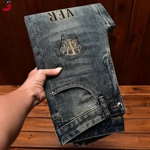 Men’s trendy brand light luxury jeans in a new slim fit with perforated patches, trendy floral embroidery, and an elastic waistband