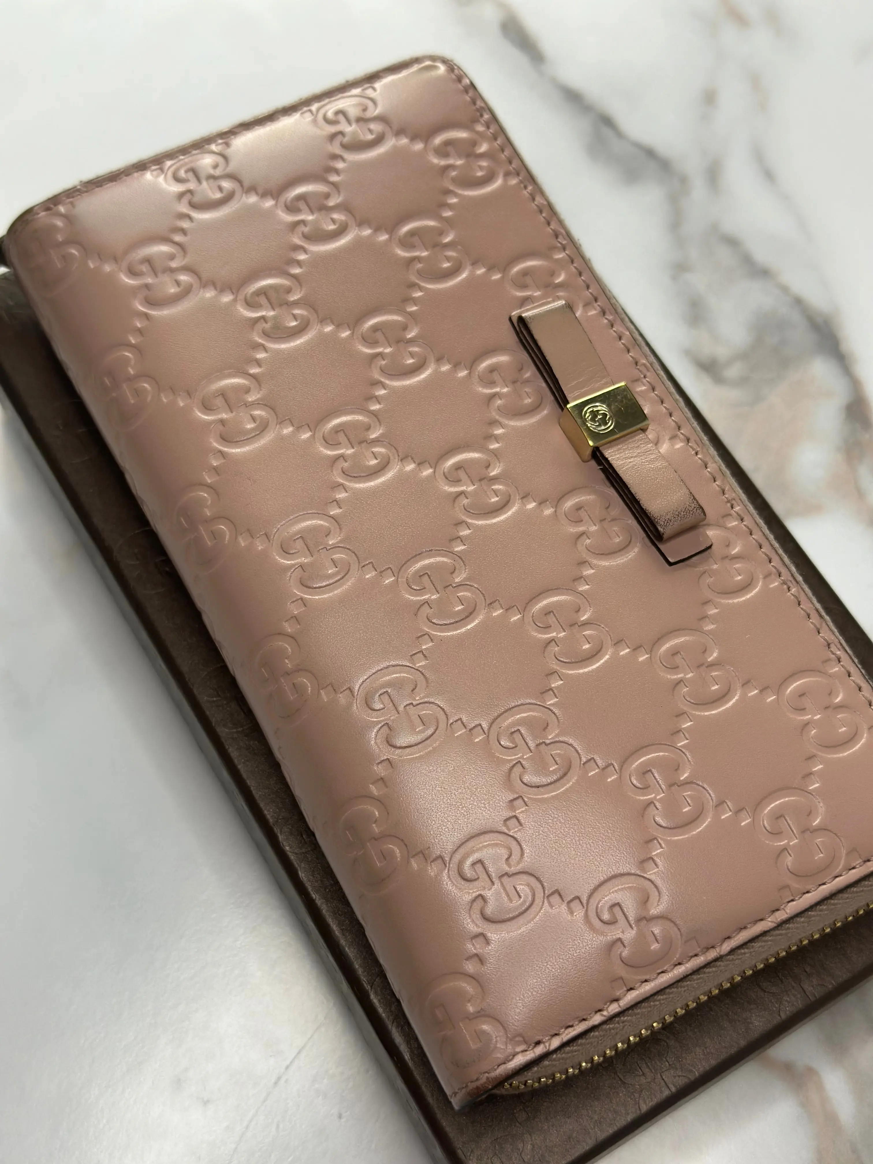 Pre-owned GUCCI leather Small Leather Goods Guccissima continental zip around wallet with a bow detail in a rose beige leather
