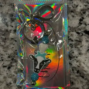 Moo-dy Teal Heart Keychain with Cow Design and Sparkling Beads for Stylish Accessory in Holographic Packaging