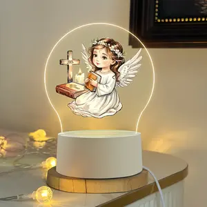 An angel acrylic night light, specially designed for First Holy Communion, featuring Bible and cross motifs. This creative LED table lamp can be used as a home decoration. It is powered by USB and provides low-power consumption and eye-friendly warm light