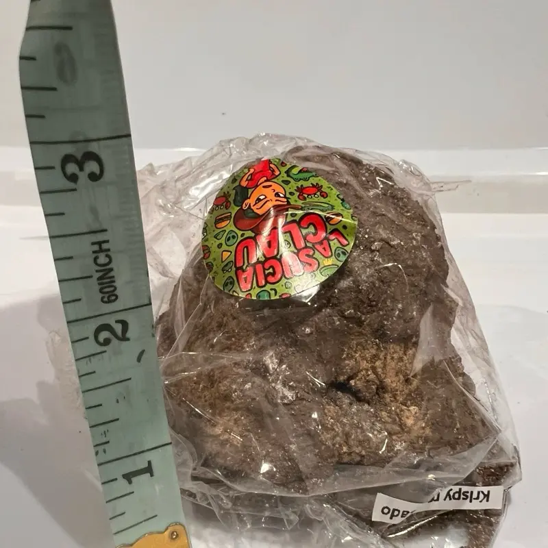 Claudia la sucia- crispyn repoado- clay brown in a form of a ball wrapped in a plastic bag