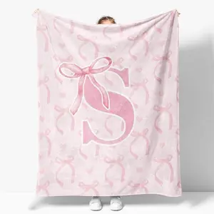 Custom-made pink ribbon blanket with initials, made of soft flannel, a personalized keepsake, perfect for a baby girl's first birthday celebration or home décor. Suitable for both children and adults, it's a wonderful gift for kids, family, and friends.
