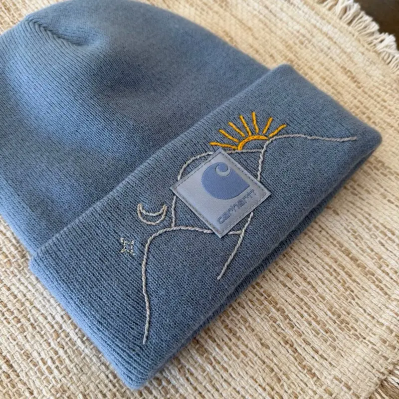 Carhartt Mountain Beanie in Light Blue with Embroidered Sun and Moon Design for Winter Wear